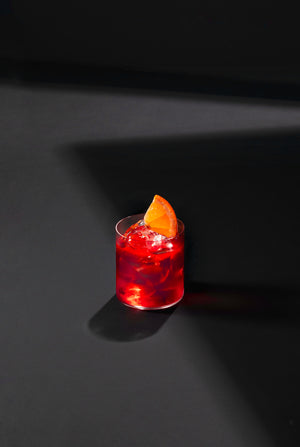 Glass of negroni cocktail with ice and slice of orange