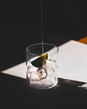 Cocktail being poured into a glass with ice